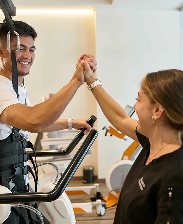 Imagen de un joven caminando con un arnés de rehabilitación.
