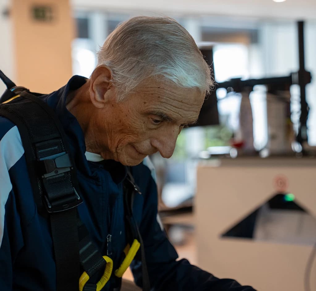 Persona mayor con arnés caminando.