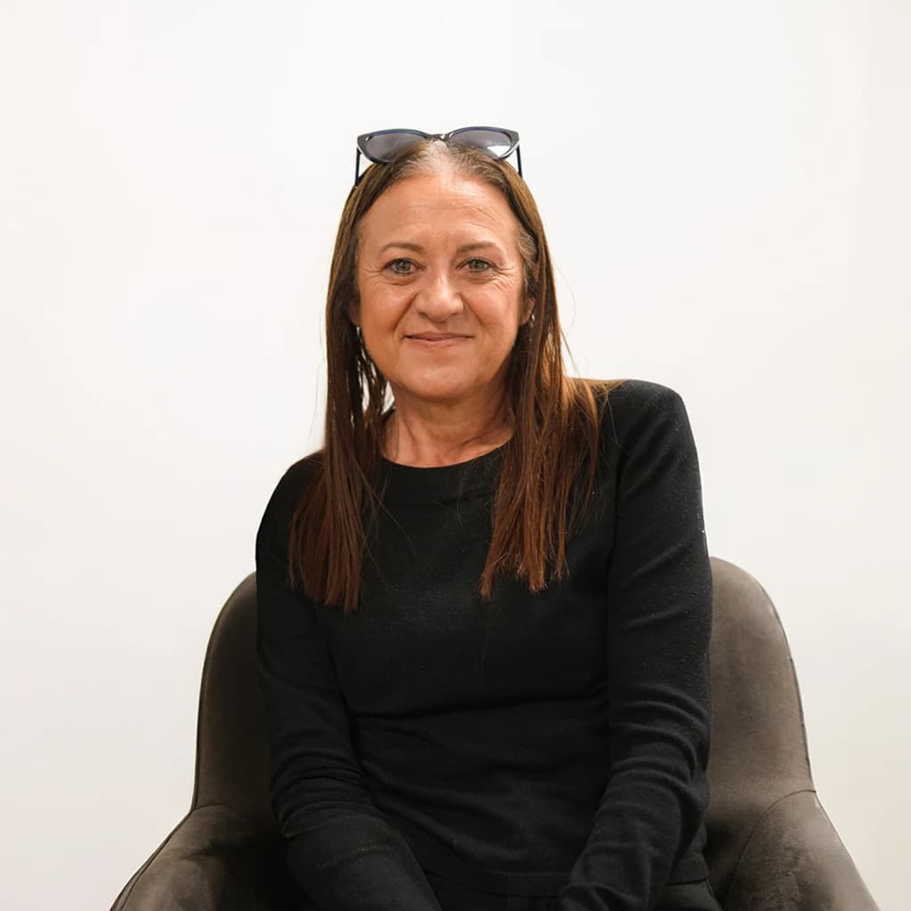 Mujer sentada sonriendo.