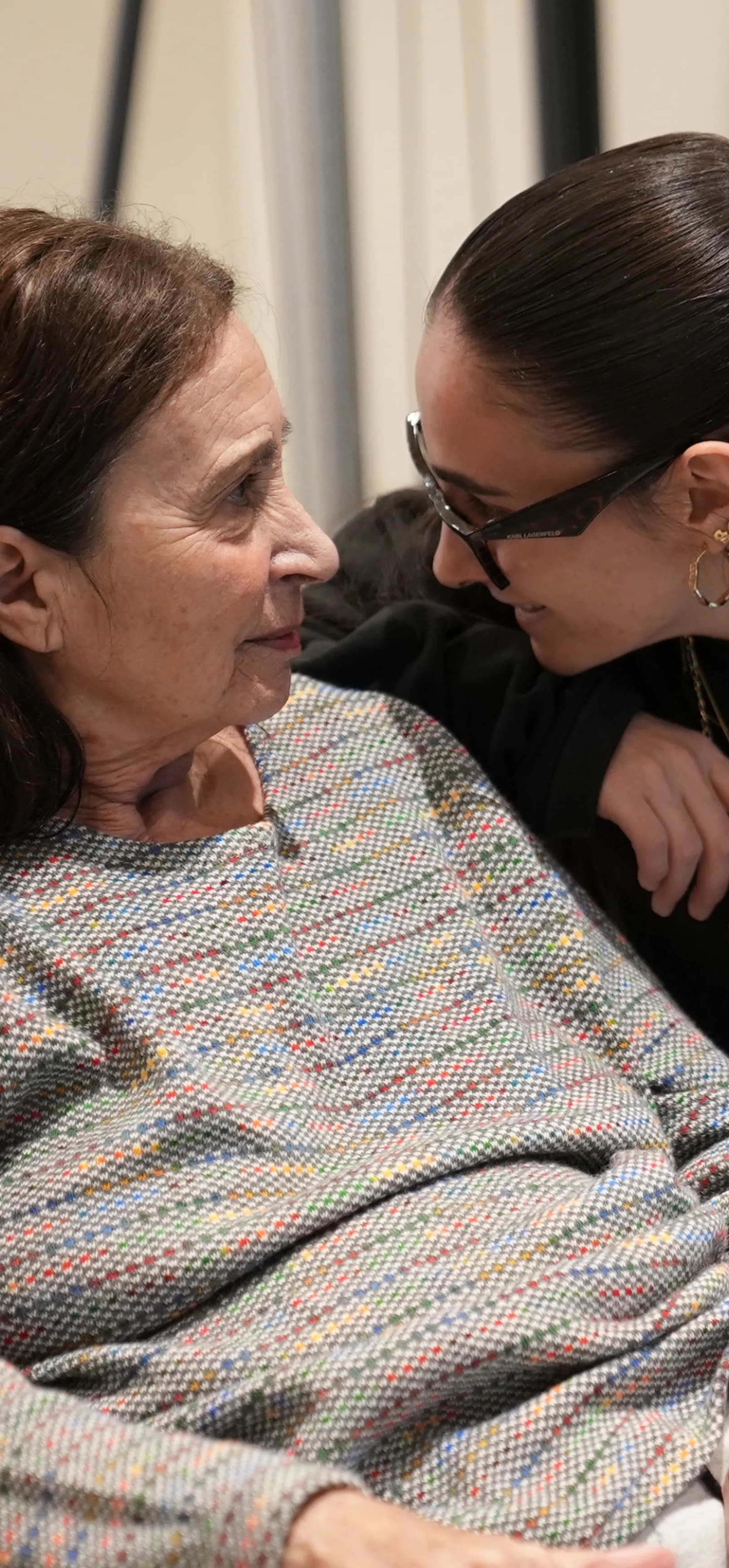Imagen de dos niñas cogidas mirando a la cámara sonriendo.