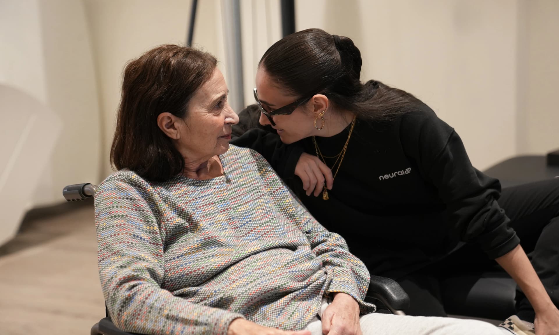 Imagen de dos niñas cogidas mirando a la cámara sonriendo.
