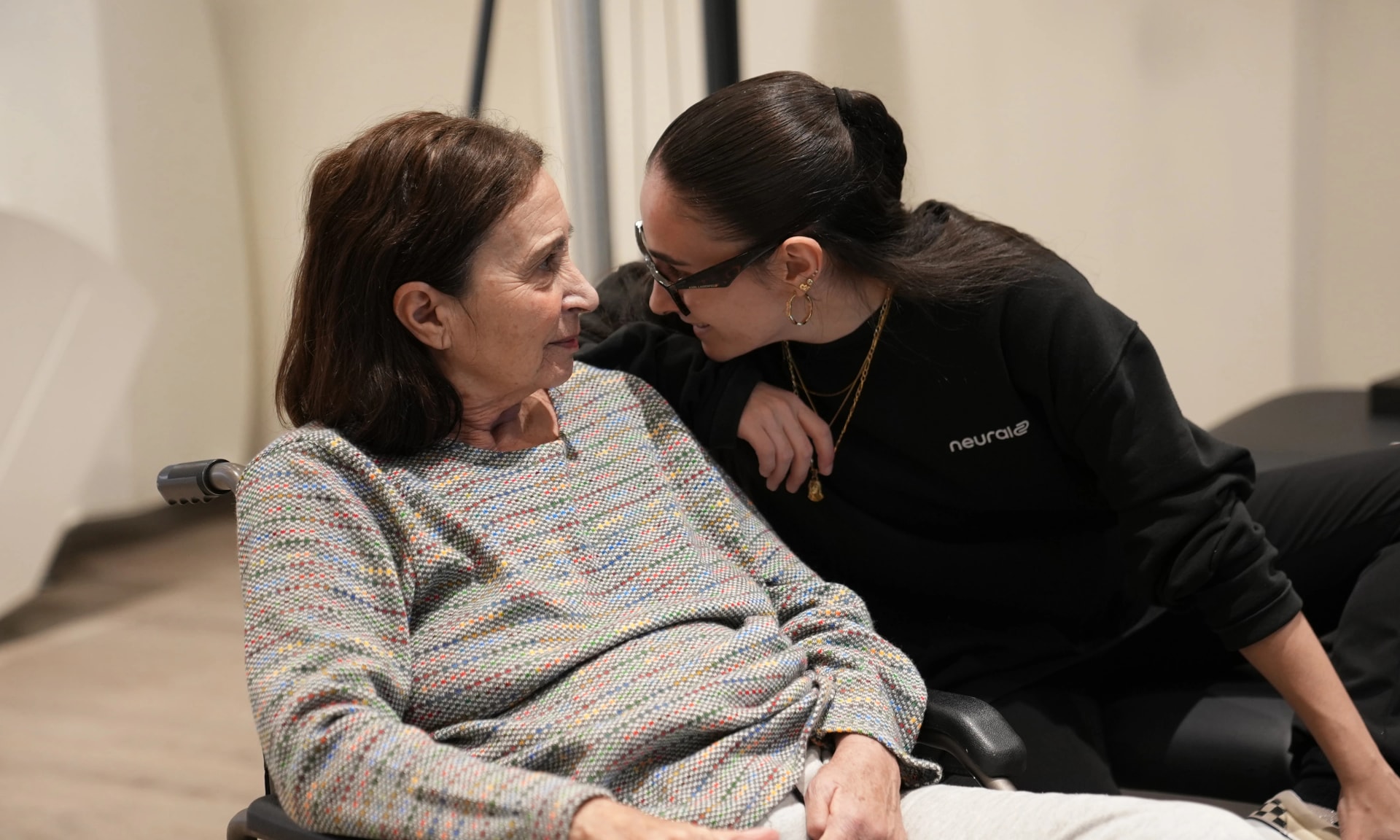 Imagen de dos niñas cogidas mirando a la cámara sonriendo.